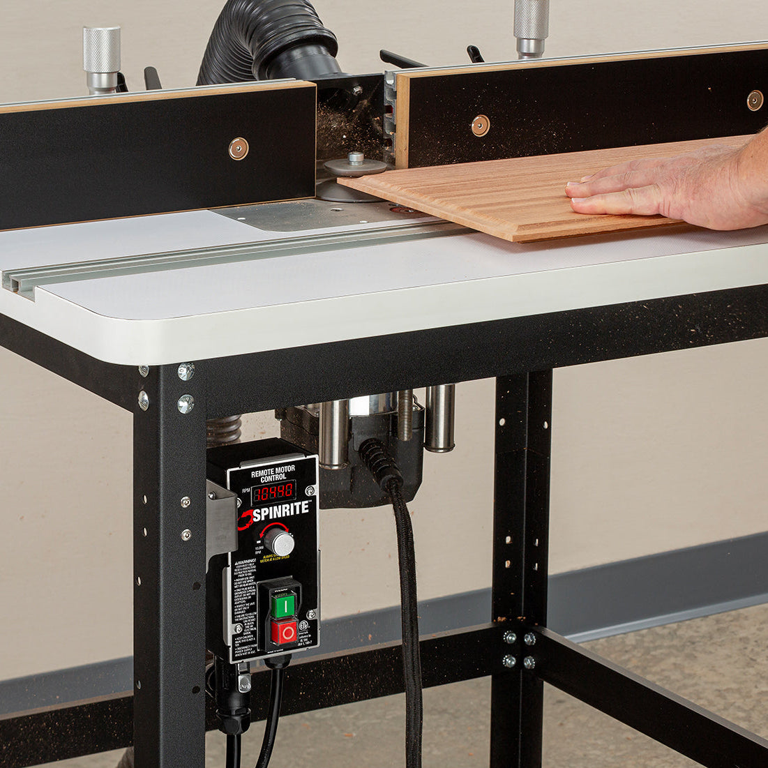 Router table with a person using it to cut wood, featuring a large LED read-out.